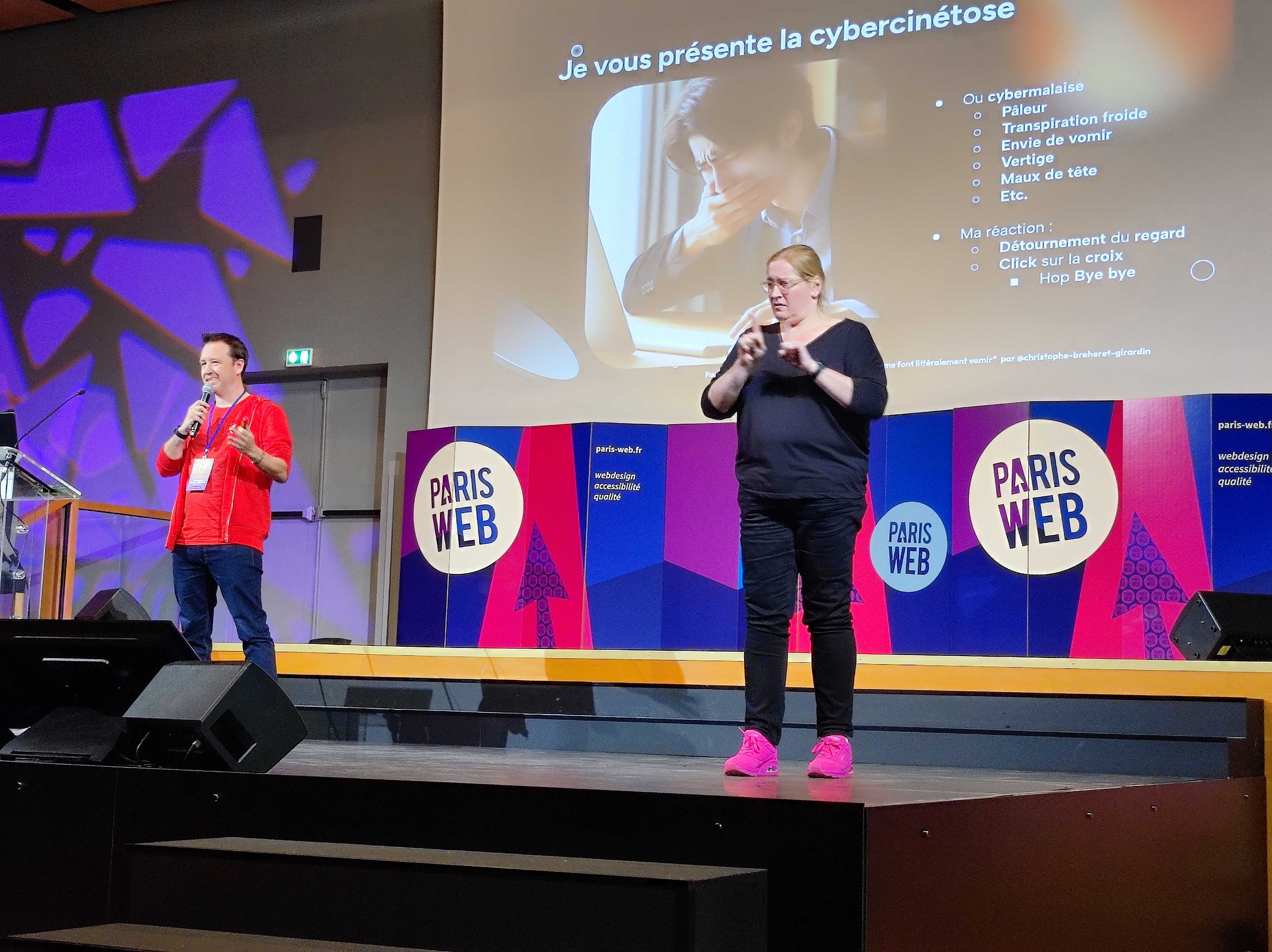 Christophe Breheret-Girardin pour la conférence "Vos présentations et vos sites me donnent littéralement envie de vomir". Une interprète le traduit en LSF.